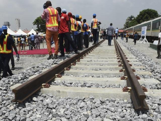 Workers stand along a prototype railway line, to be constructed by China Railway Construction Corporation, at the launch of the construction of a railway between Lagos and Ibadan in March 2017. Photo: AFP/PIUS UTOMI EKPEI
